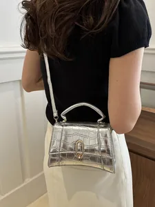 Silver crocodile pattern mini square bag featuring metallic lock and top handle detail