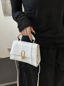 Detail of white crocodile texture leather handbag with gold U-shaped metal lock
