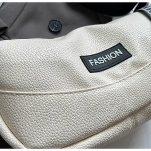 Détail macro du sac sous le bras blanc crème en cuir grainé avec écusson Fashion