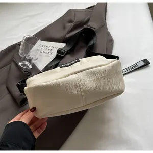 Détail du sac hobo crème texturé litchi avec bandoulière contrastée et logo mode
