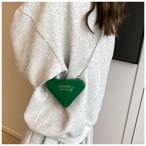 Grüne dreieckige Mini-Kettentasche mit Goldaufdruck auf grauem Sweatshirt