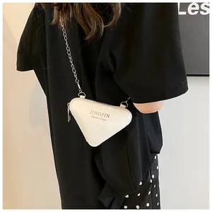 Detailansicht der weißen dreieckigen PU-Ledertasche mit silberner Kette und Mode-Schriftzug