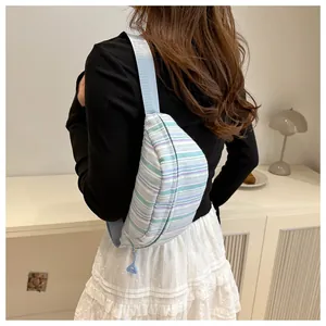 Dettaglio borsa pettorale in nylon a righe con trama plissettata e tracolla blu