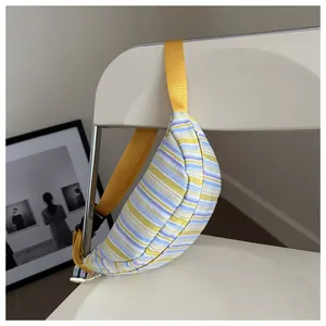 Dettaglio di borsa a tracolla in nylon a righe colorate su una sedia bianca
