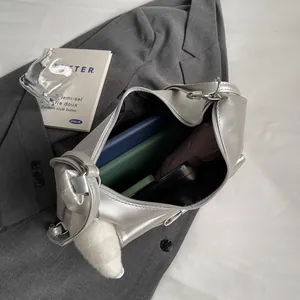 Grote zilveren shopper met metallic afwerking, gevuld met boeken en een paraplu