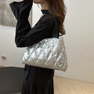 Silver quilted tote bag with metallic finish and black handles for trendy women