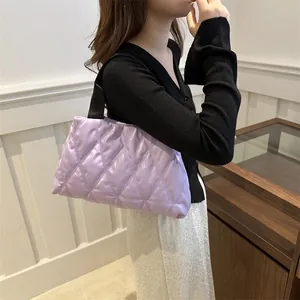 Detail of lavender quilted puffer bag with chic diamond stitch and black shoulder strap