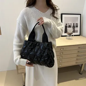 Chic black quilted puffy tote bag with soft diamond stitching and top handle