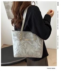 Detail of grey marble wave pattern tote bag with gold rivets on shoulder strap