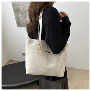 Detail view of large tote bag with elegant marble pattern and gold metal hardware