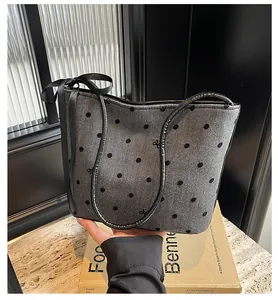 Detail van de stippen tote bag met visgraattextuur en zwarte satijnen strik decoratie