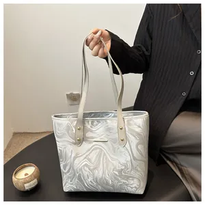 Detail of large capacity tote bag featuring marble pattern print and metal rivet handles