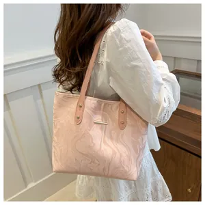 Pink marble pattern tote bag with metal bar detail shown worn with a white lace dress