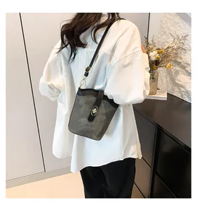 Retro bucket bag with turn-lock closure on model, gray and black contrast shoulder bag