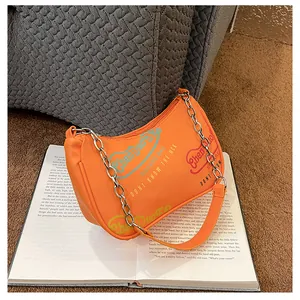 Dettaglio borsa hobo arancione con graffiti, catena d'argento e tracolla