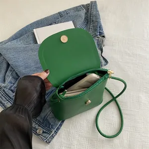 Minimalist green mini saddle crossbody bag with interior space for phone and card holder