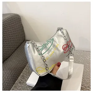 Dettaglio borsa a mezzaluna argento con graffiti colorati e tracolla a catena