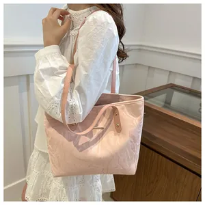 Detail of light pink tote bag featuring marble pattern and elegant gold hardware accents