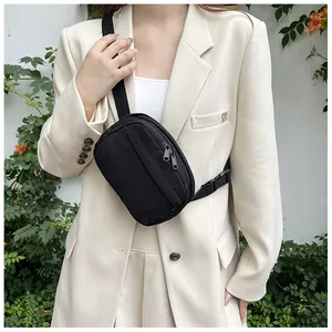 Minimalist black nylon sling bag with multi-zipper detail on model with white blazer