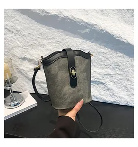 Detail of vintage bucket bag featuring grey matte fabric and gold twist lock closure