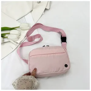 Detail of pink nylon crossbody bag with adjustable strap and floral decor setup