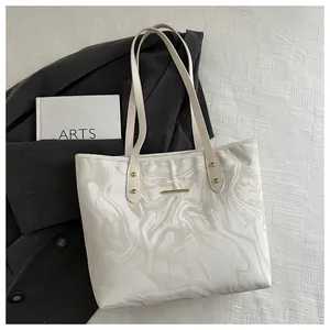 Close-up of marble texture on tote bag with golden rivets and elegant handle details