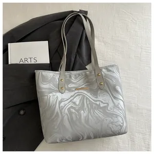Close-up of marble pattern tote bag with golden hardware and leather handles