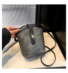 Macro detail of vintage bucket bag with contrast stitching and metal turn-lock closure