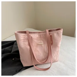 Detail of pink marble pattern tote bag with silky texture and golden metal hardware