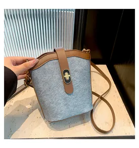Detail of vintage bucket bag featuring grey felt texture and brown leather turn-lock closure