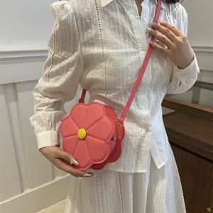 Pink flower shaped PU leather crossbody bag with yellow center and adjustable shoulder strap