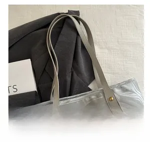 Detail of grey marble pattern tote bag with golden metal nameplate and handles