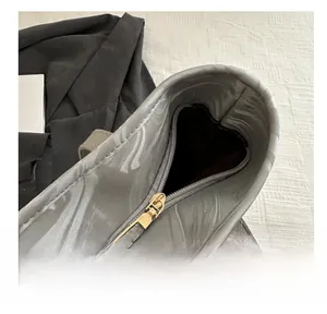Close-up of smooth golden metal zipper on a grey marble pattern tote bag details
