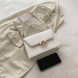 Minimalist white leather crossbody bag with gold lock buckle and top handle