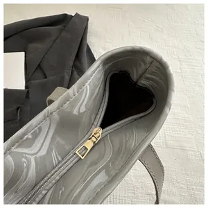 Detailed close-up of marble pattern tote bag with gold metal zipper and stitching
