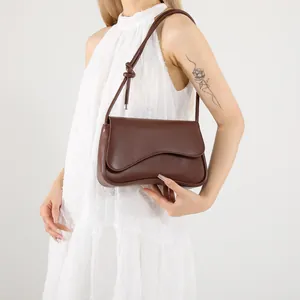 French style dark brown underarm bag with wavy flap and knot detail on shoulder strap