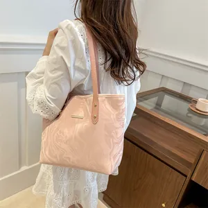 Pink marble pattern tote bag with gold logo plaque shown on a model for daily commute