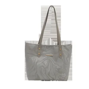 Large capacity grey tote bag with marble print and gold metal handles on white background