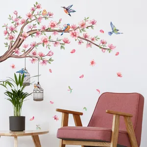 Detalle de vinilos de pared con ramas de flores rosas, pájaros y jaulas vintage
