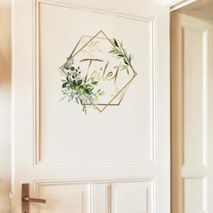 Close-up of Toilet door sticker featuring golden geometric frame and watercolor leaves