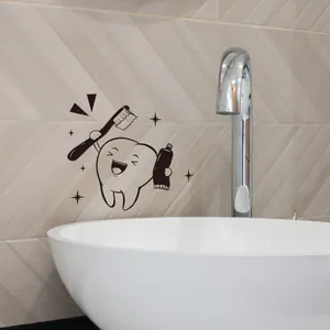 Adhesivo dental de dibujos con cepillo en pared de azulejos de baño junto al grifo