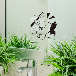 Detalle de lindas pegatinas de dientes en un espejo de baño con cepillo y pasta de dientes