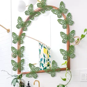 Green glitter hollow 3D butterfly wall stickers decorating a mirror in a room