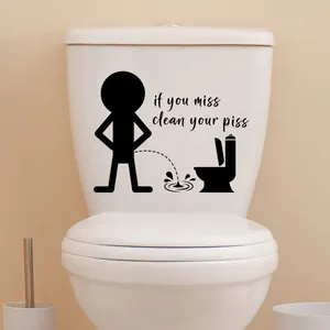 Sticker WC noir avec texte 'if you miss clean your piss' sur réservoir de toilettes blanc