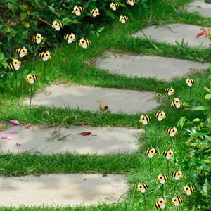 Outdoor garden bee stakes set showing decorative insects installed along a stone path