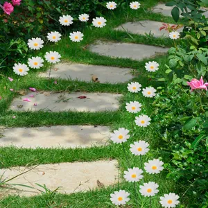 Outdoor white daisy garden stakes lining a stone path in a lush green lawn setting