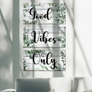 Detail of three-piece eucalyptus leaf wall art featuring Good Vibes Only text in nature light
