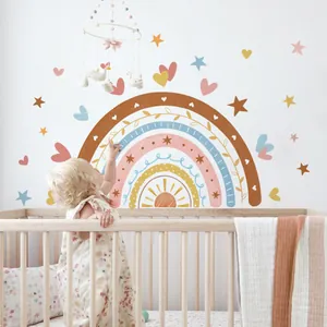 Detail showing a boho rainbow wall decal in a nursery setting with a toddler