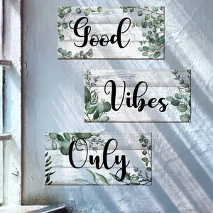 Detail view of eucalyptus leaf wall stickers with Good Vibes Only text on wood texture background