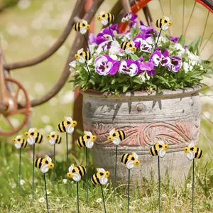 Detailed view of yellow bee garden stakes decorative pins placed in a flower pot